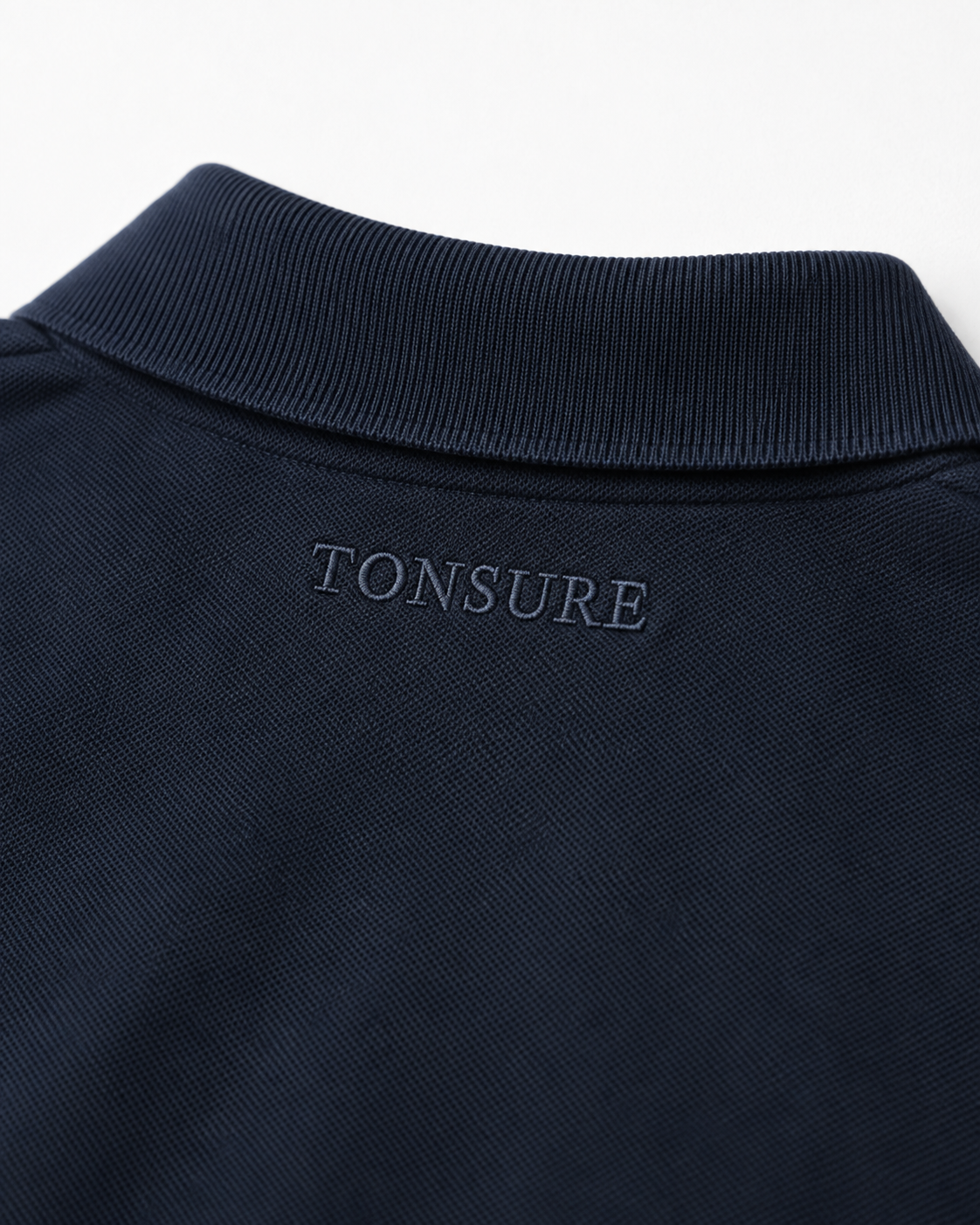 Detaljefoto af Tonsure broderi på Milton polo dark navy