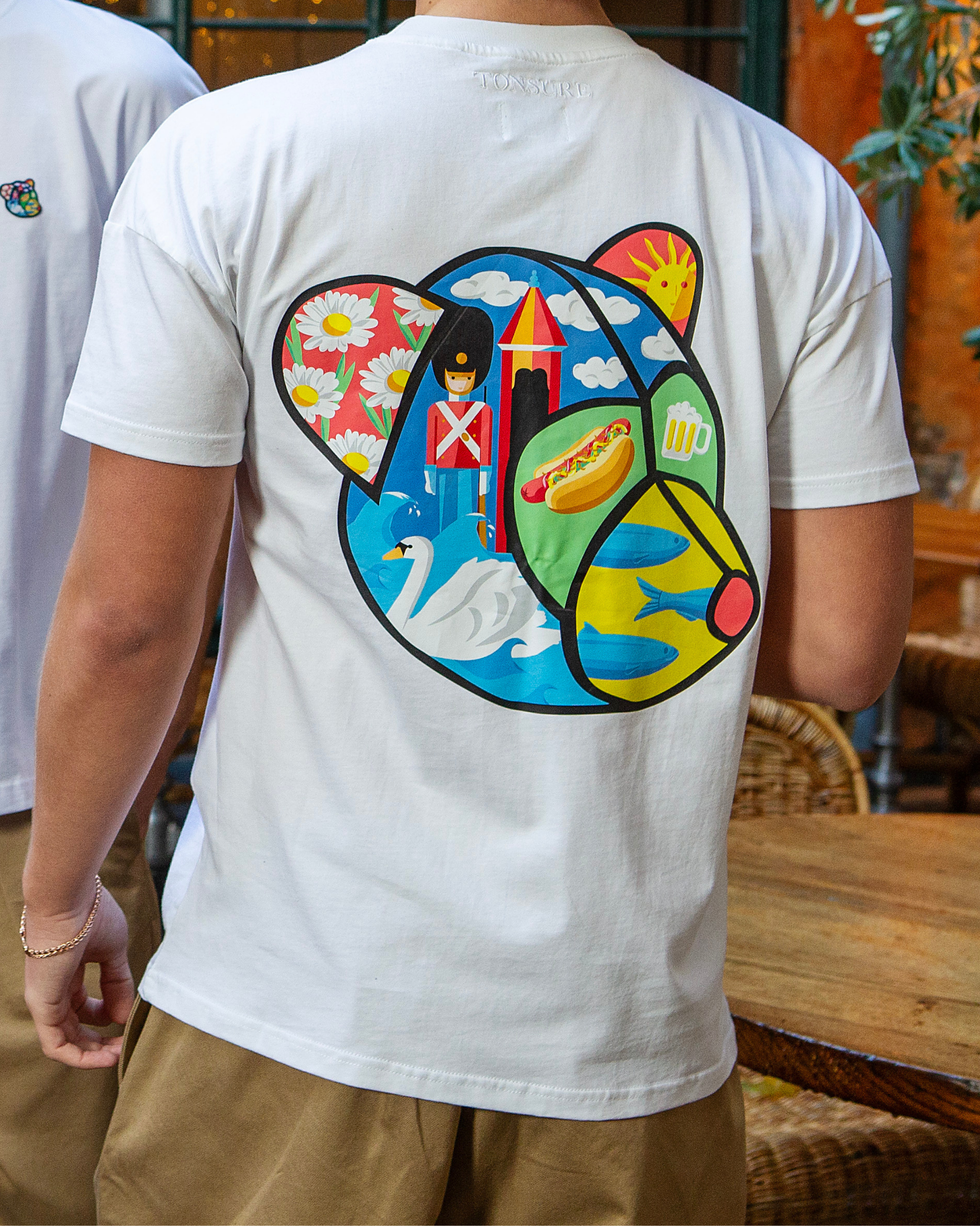 Hvid t-shirt til mænd i bæredygtigt bomuld fra danske herretøjsbrand Tonsure. Ryggen er prydet med Teddy Copenhagen print i stor størrelse.