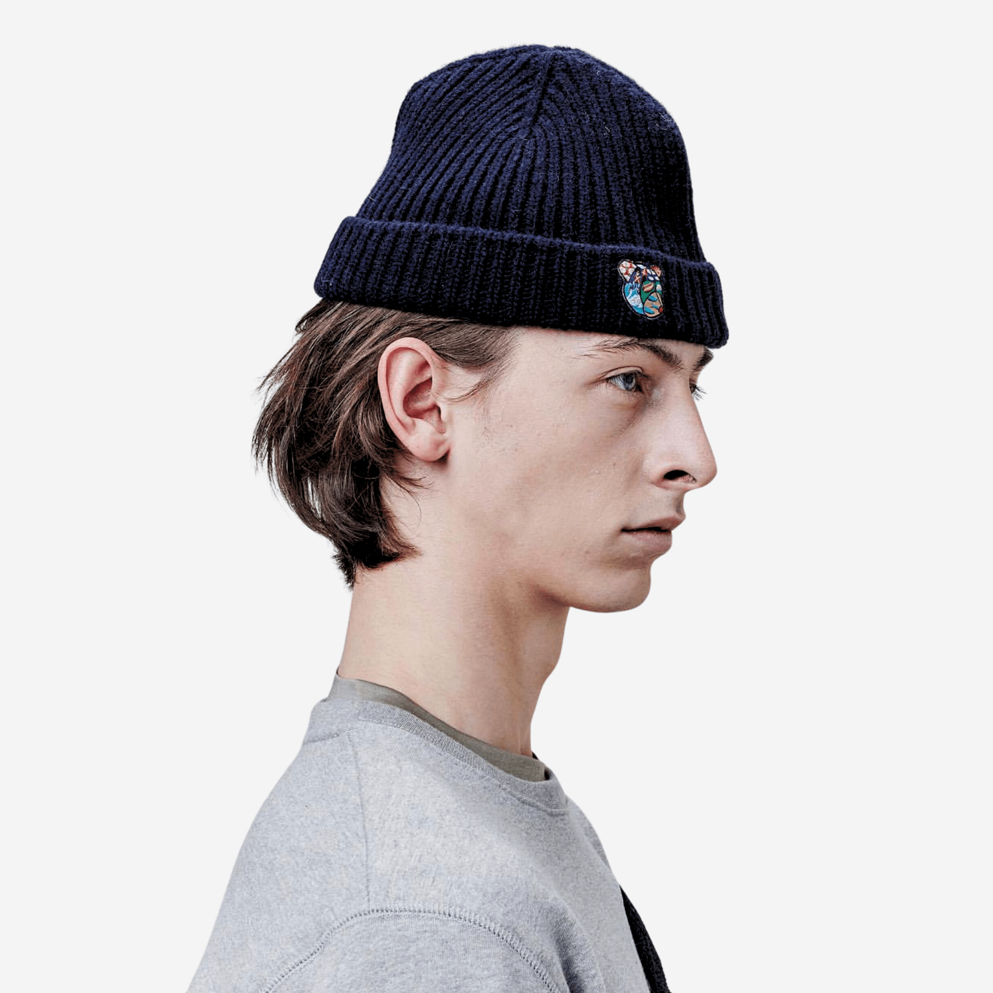 Rickie Beanie Navy - Tonsure. Hold varmen med Tonsure’s strikhue til mænd, der kombinerer tidløst design med maksimal komfort. Fremstillet af blødt og slidstærkt uld, sikrer denne beanie, at du er godt beskyttet mod kulden, samtidig med at du ser stilfuld ud. Den minimalistiske skandinaviske æstetik gør denne hue alsidig og let at kombinere med ethvert outfit.